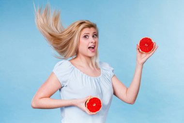 Meyve kırmızı greyfurt yarı tutan kadın