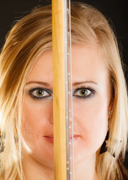 Mujer rubia sosteniendo la guitarra eléctrica, fondo negro — Foto de Stock