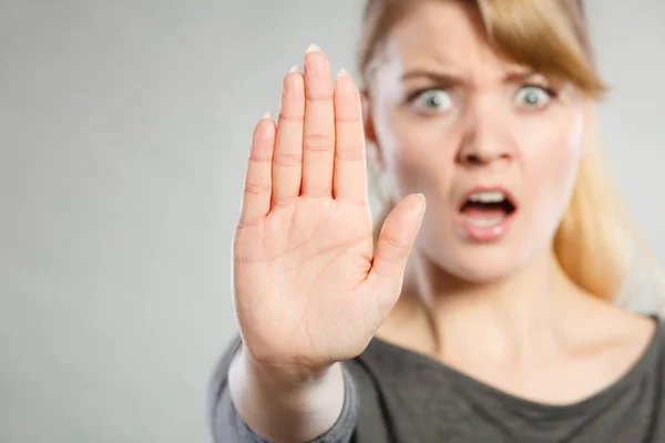 Vrouw toont stopbord door haar hand. — Stockfoto