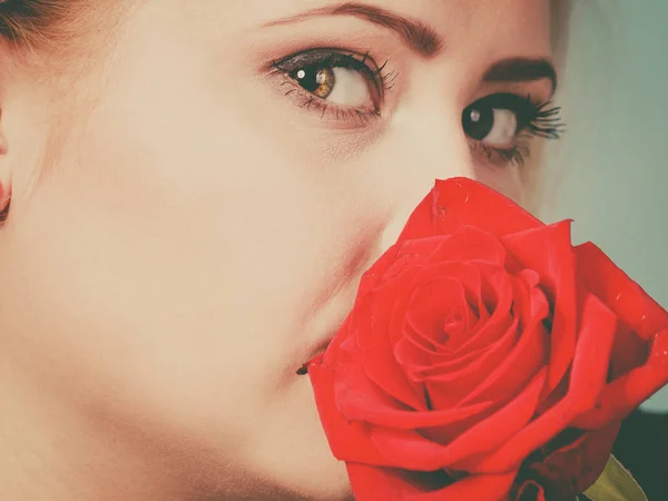 Nádherná žena drží červený květ růže. — Stock fotografie