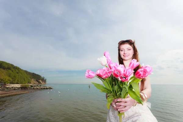 Csokor virágot tartó tengerparti női — Stock Fotó