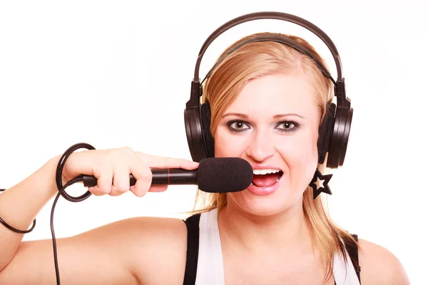 Женщина поет для микрофона в наушниках — стоковое фото