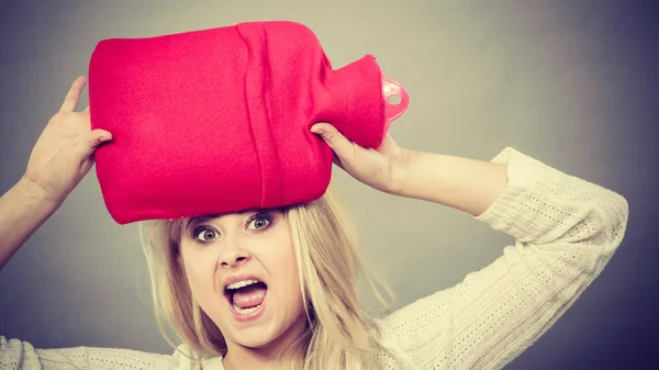 Vrouw met rode hot waterfles op hoofd — Stockfoto