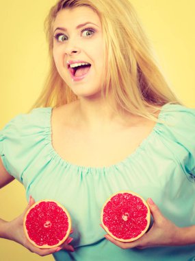 Kırmızı greyfurt meme üzerinde tutan kadın