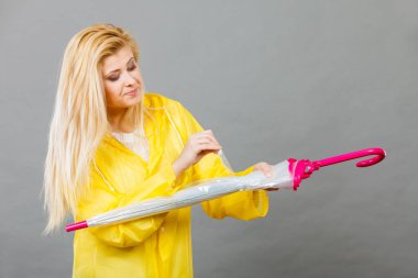 Kadın giyiyor yağmurluk kapanış şemsiye