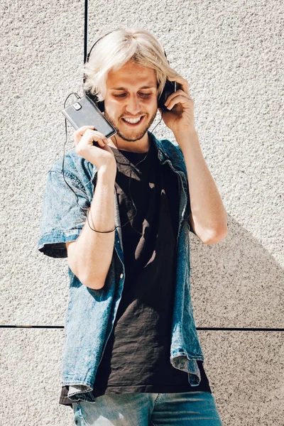 Hipster smiling man listening music through headphones — Stock Photo, Image