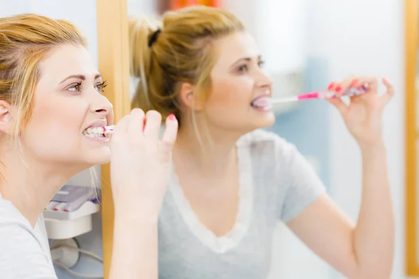 Woman brushing cleaning teeth in bathroom — Stock Photo, Image