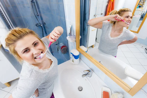 Donna spazzolatura pulizia dei denti in bagno — Foto Stock