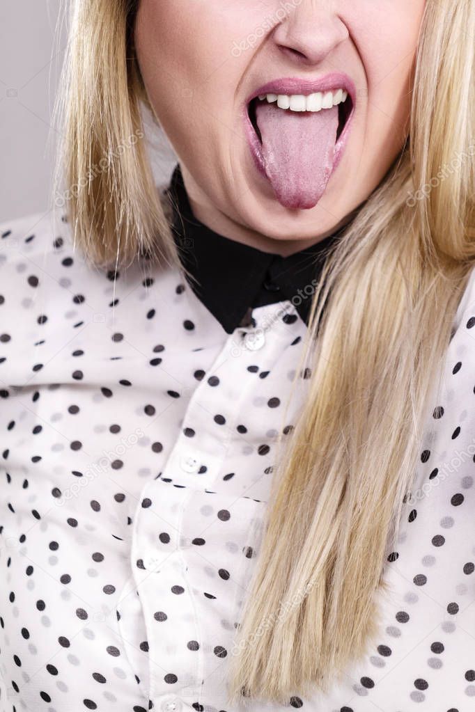Blonde unrecognizable woman sticking tongue out