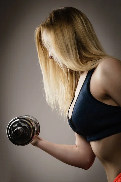 Подходящая женщина делает упражнения с гантелями — стоковое фото