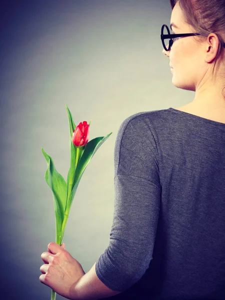 Blonde Frau mit einer einzigen Tulpe. — Stockfoto