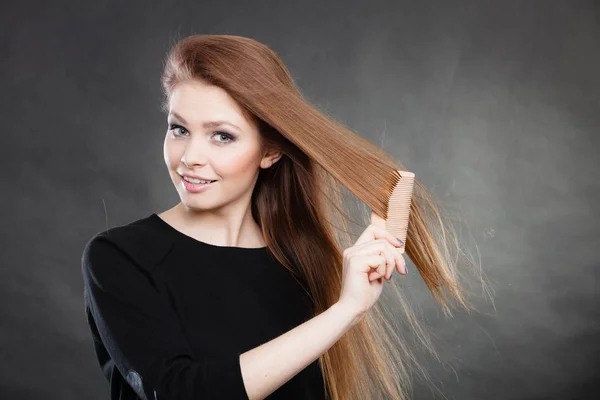 Hosszú hajú nő fésülködés a haját. — Stock Fotó