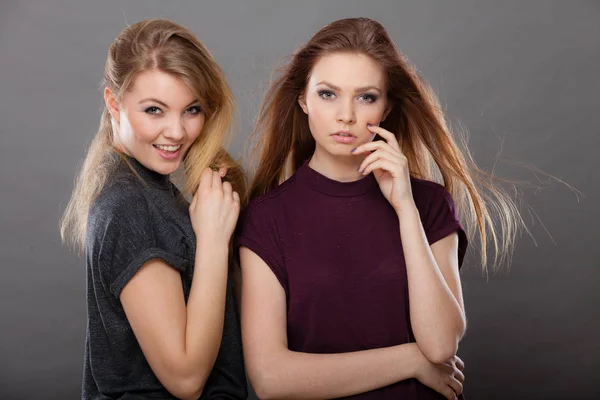 Two beautiful women, blonde and brunette posing — Stock Photo, Image