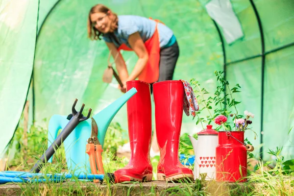 Agricultor feminino e ferramentas de jardinagem no jardim — Fotografia de Stock