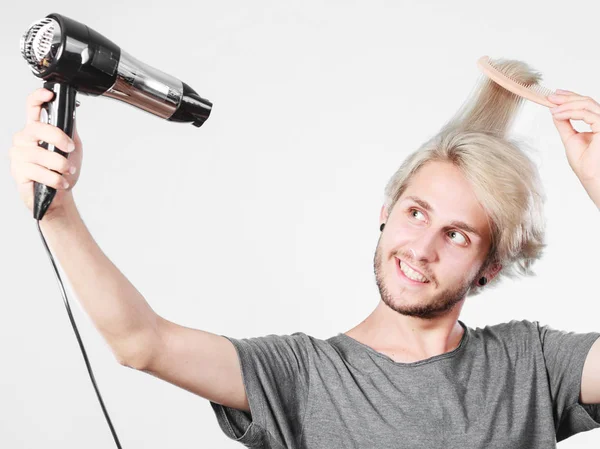 Joven hombre secando el cabello con secador de pelo —  Fotos de Stock