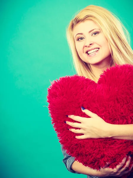 Mujer feliz sosteniendo almohada roja en forma de corazón — Foto de Stock