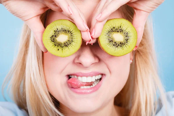 Gözlük gibi yeşil kivi tutan kadın