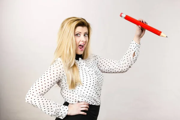 Joyful woman holds big pencil in hand — Stock Photo, Image