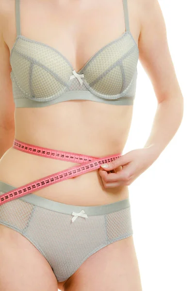 Mulher em lingerie medindo sua cintura com fita métrica . — Fotografia de Stock