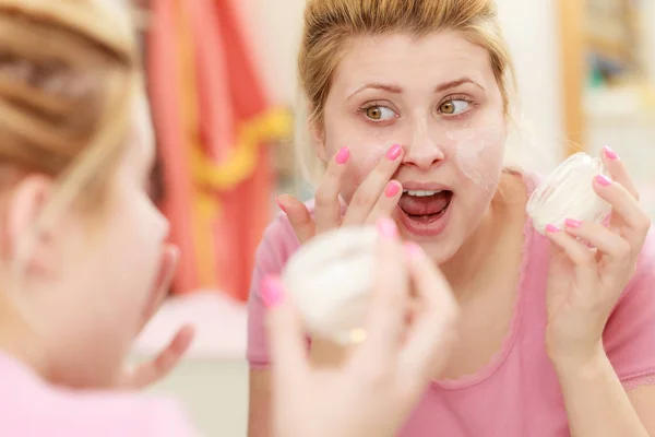 Mujer aplicando crema facial con el dedo — Foto de Stock