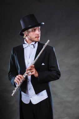 Zarif giyimli müzisyen flüt tutan