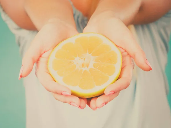 De helft van de gele grapefruit citrusvruchten in menselijke hand — Stockfoto