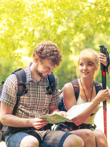 Excursionistas mochileros pareja lectura mapa en viaje . — Foto de Stock