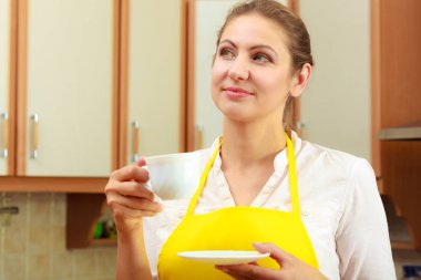 Olgun kadın mutfakta kahve holding.