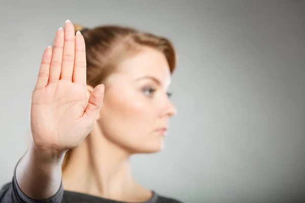 Vrouw toont stopbord door haar hand. — Stockfoto