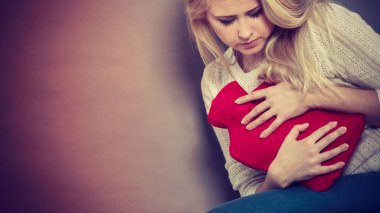 Holding sıcak su şişesi kadının duygu mide krampları