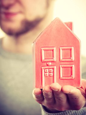 Genç adam evin üstünde palmiye holding.