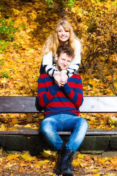 Lovers couple in autumn park on bench — Stock Photo, Image