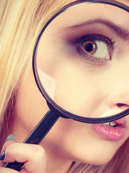 Woman looking through magnifying glass Stock Picture