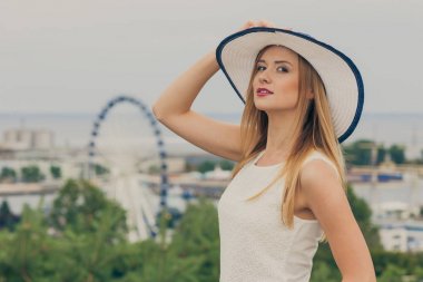 Güneş şapka ve beyaz bluz giyen çekici kadın