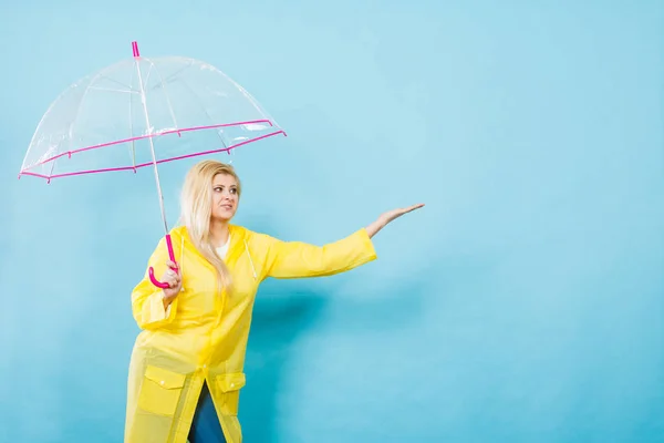 Nő visel esőkabát, esernyő, időjárás ellenőrzési gazdaság — Stock Fotó