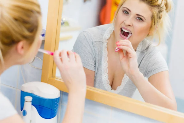 Mujer cepillarse los dientes de limpieza en el baño —  Fotos de Stock