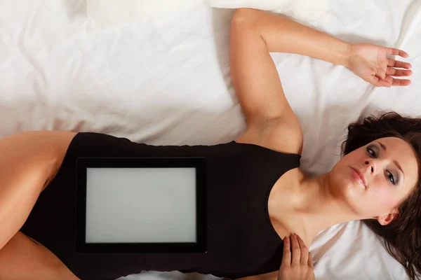 Sexy ragazza pigra sdraiata con tablet touchpad sul letto — Foto Stock