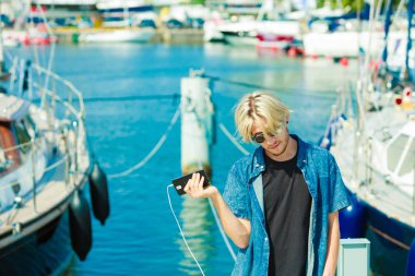 Onun smartphone kullanarak dışında sarışın adam