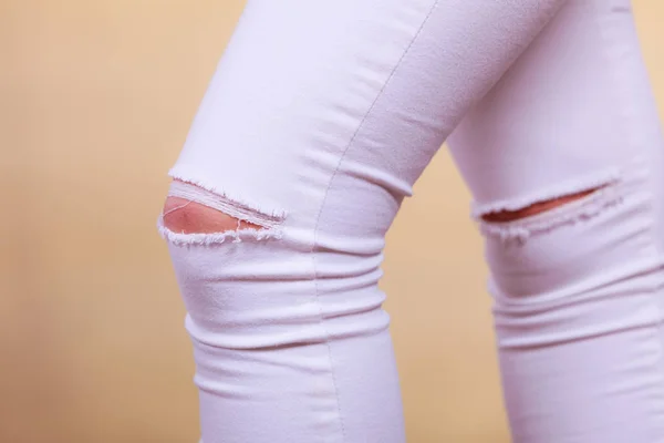 Těsný bílé kalhoty džíny s dírami na kolenou — Stock fotografie