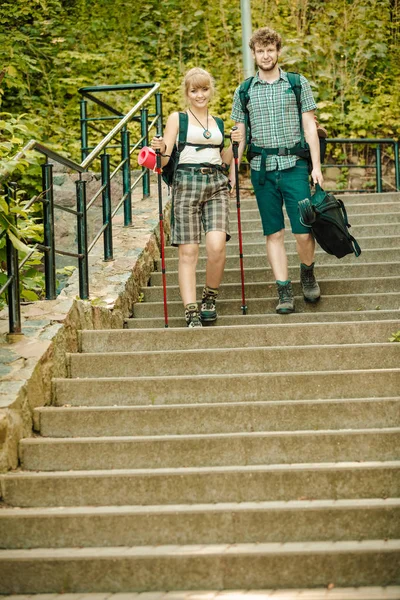 Two people tourists hiking walking on stairs.