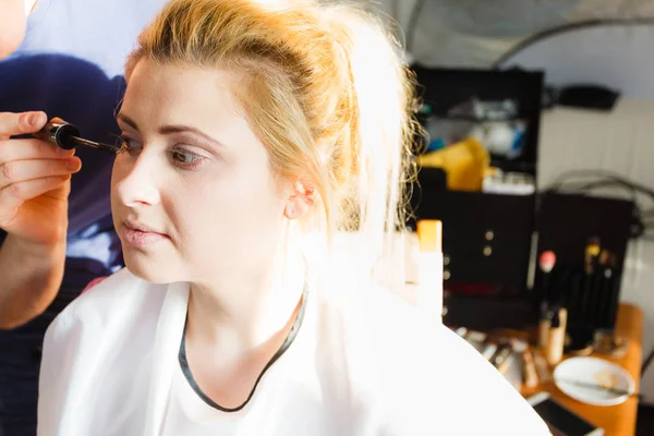 Woman getting eyelashes makeup done