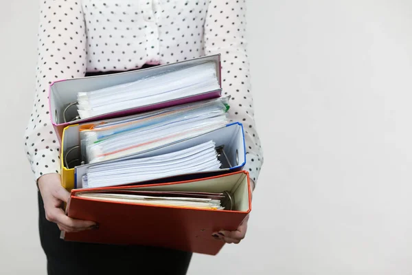 Mulher segurando pesados ligantes coloridos com documentos — Fotografia de Stock