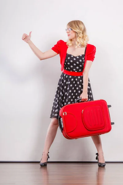 Frau mit rotem Koffer trampt — Stockfoto
