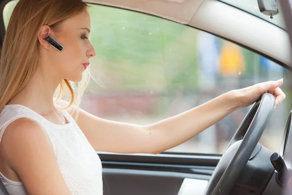 Mujer conduciendo coche con auriculares —  Fotos de Stock
