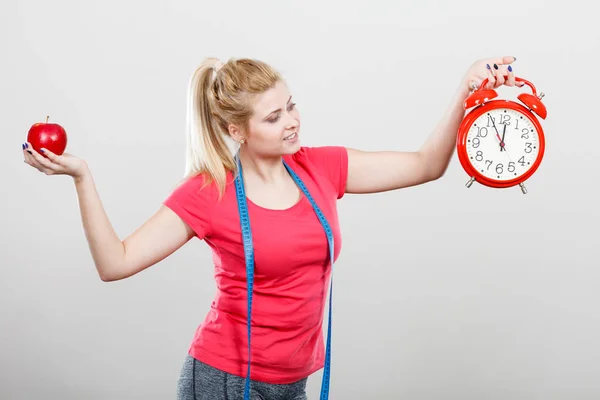 Mujer feliz sosteniendo reloj, manzana y cinta métrica — Foto de Stock