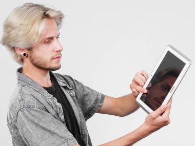 Tablet düşünme kullanarak trendy genç adam