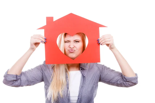 Rolig tjej håller rött papper hus med hjärta form — Stockfoto