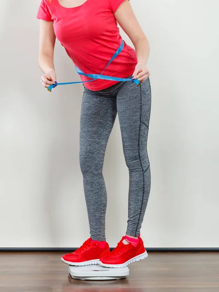 Kvinna som bär sportkläder stående på vikt maskin — Stockfoto