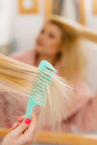 Γυναίκα που φοράει τη ρόμπα βούρτσισμα τα μαλλιά της — Φωτογραφία Αρχείου