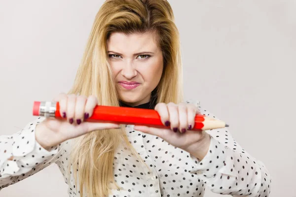 Angry woman holds big pencil in hand — Stock Photo, Image